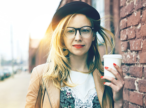 Stylish woman in the street drinking morning coffee