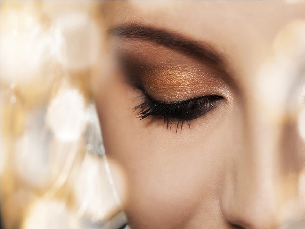 چشمانی با سایه به رنگ طلایی و دودی که نمایی زیبا از میکاپ اسموکی را نشان می‌دهد.