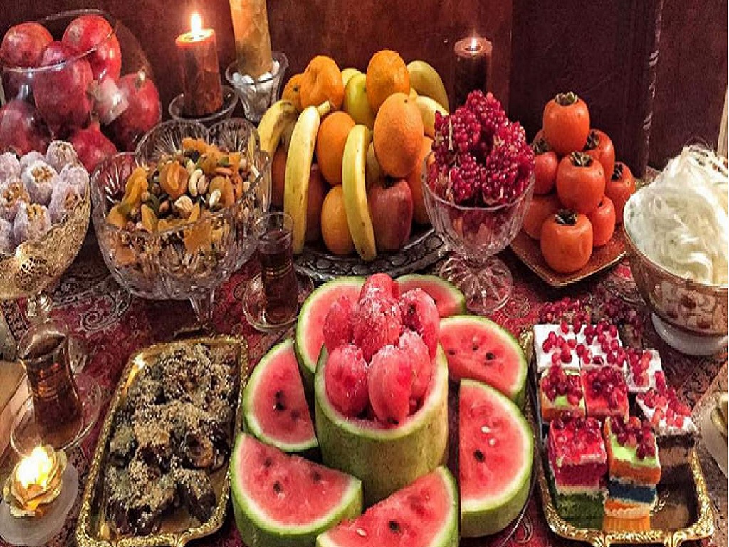 برش‌های رنگی شیرینی در کنار اسکوپ‌های هندوانه و دیگر خوراکی‌های خوشمزه شب یلدا زیبایی را به تصویر می‌کشد.